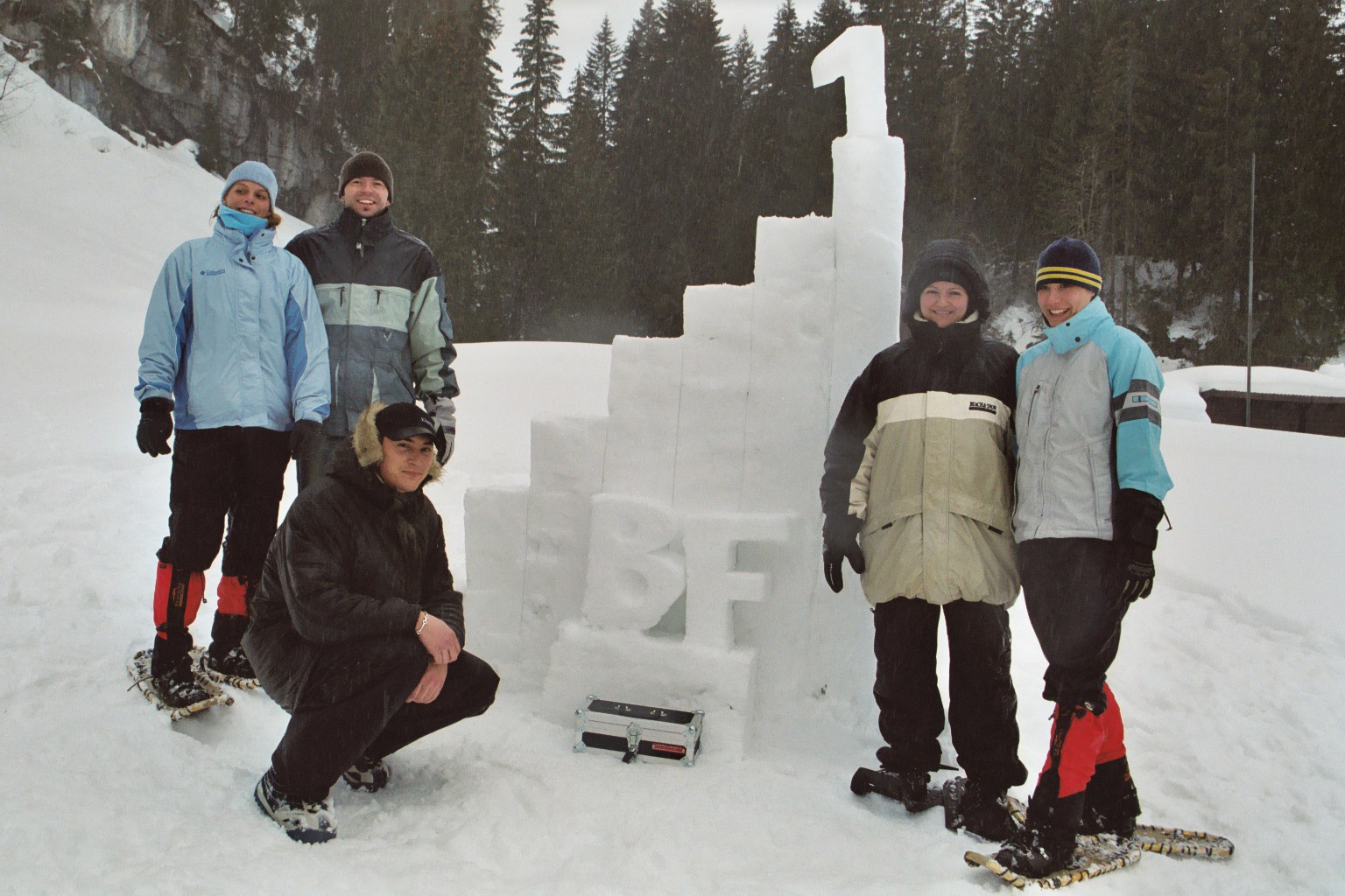 In der Mitte des Bildes ist eine treppenförmige Schneeskulptur, rechts und links der Skulptur sind je 2 bzw. 3 Personen